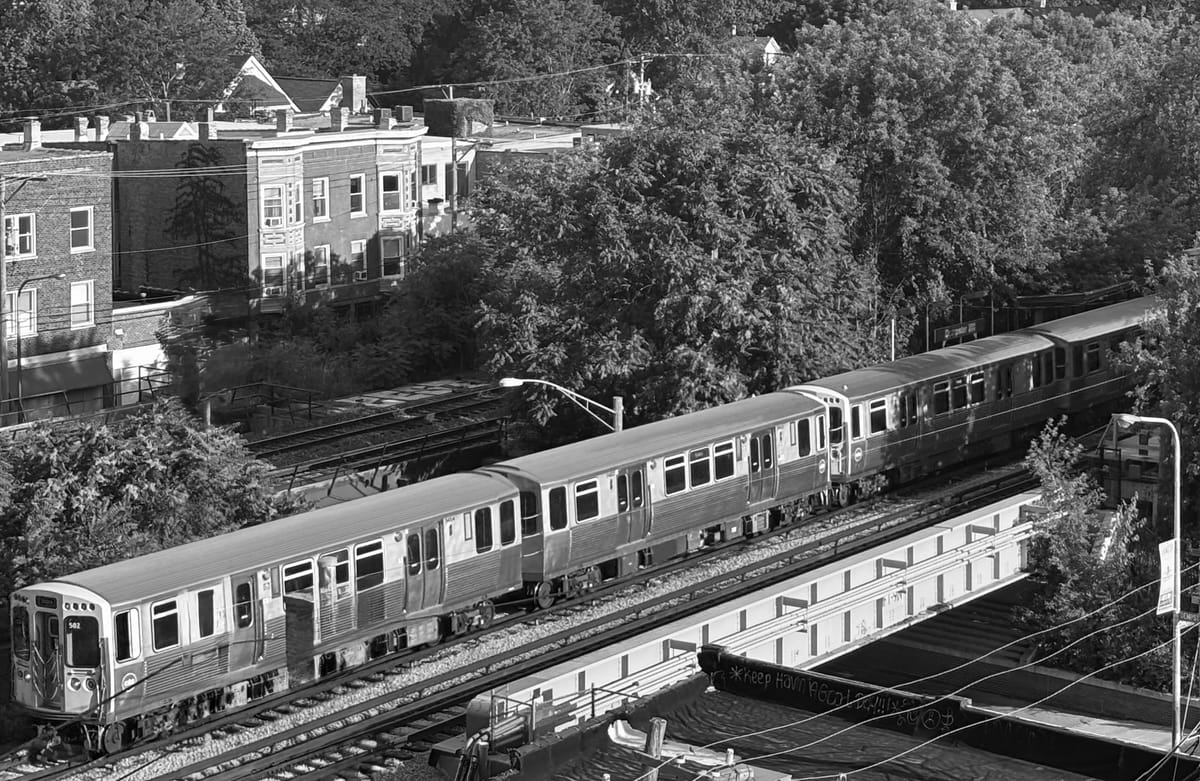 L train on tracks in Evanston. Black and white.