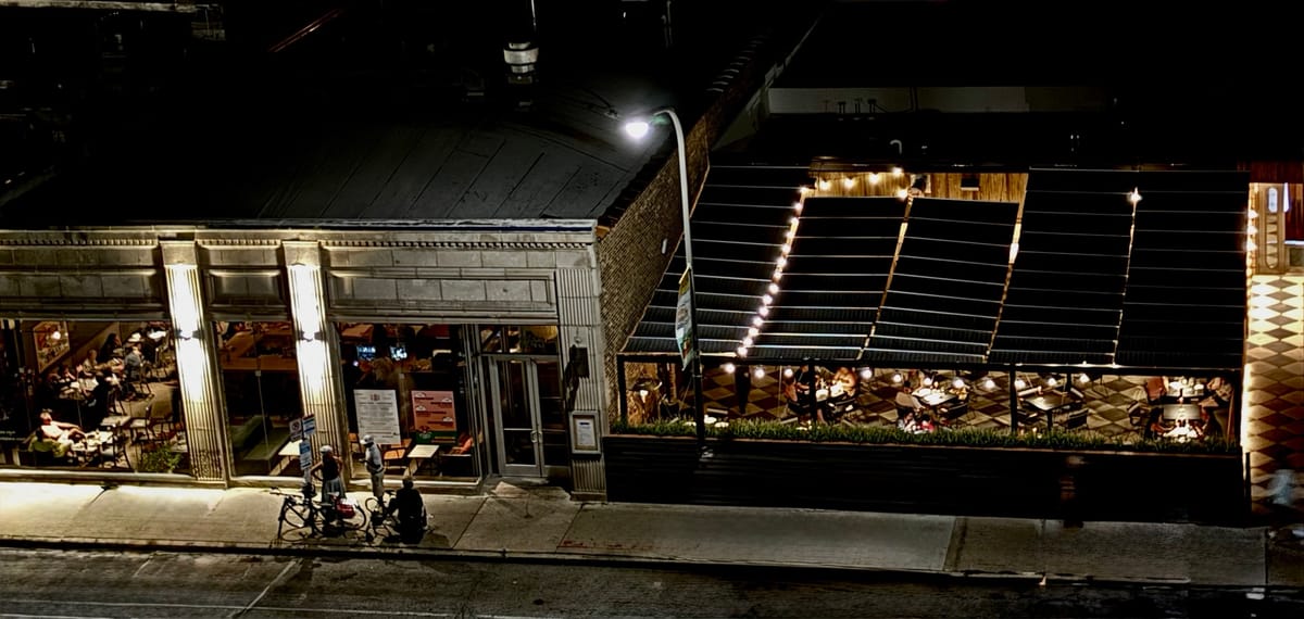 Indoor and outdoor restaurant space at night.