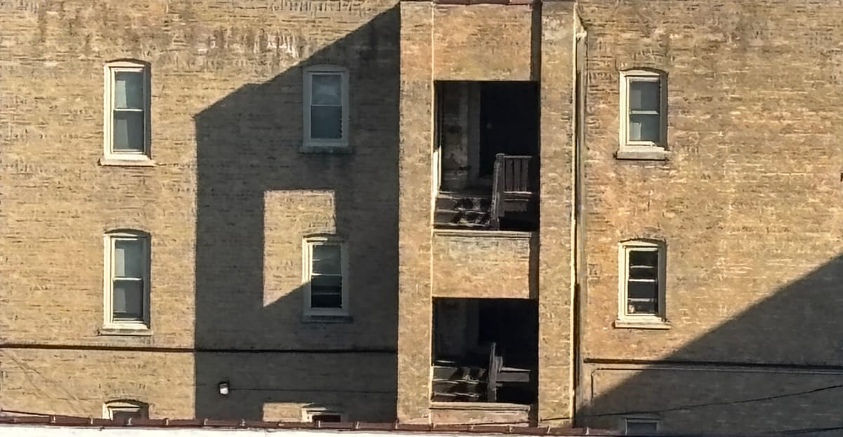 Close of up apartment building with shadows forming patterns.